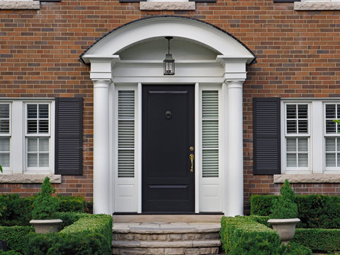 front door of house with curved covering and column