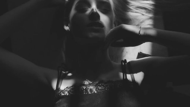 Black and white art fashion surrealistic portrait of beautiful woman with a beamof light and shadow on her face