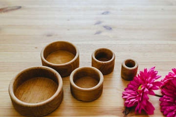 Group of round and empty wooden bowls and purple flowers with free space for text