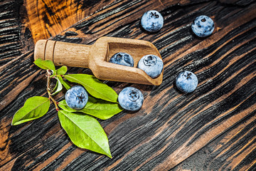 Ripe huckleberries in wooden spoon
