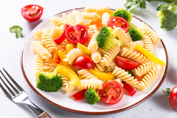 Vegan pasta fusilli with vegetables broccoli and tomatoes.