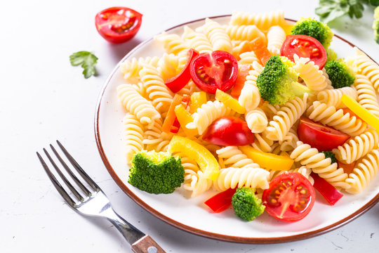 Vegan pasta fusilli with vegetables broccoli and tomatoes.