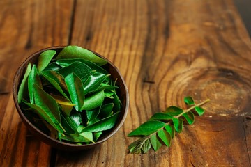 Fresh Curry leaves still life on  dark moody background © vm2002