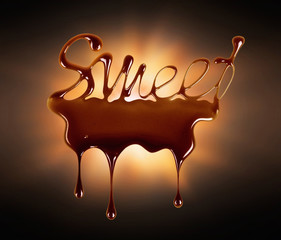 The word Sweet written with melted chocolate against a dark background