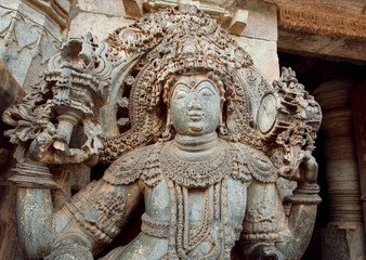 Fototapeta na wymiar Sculpture of a guard at entrance of carved 12th century historical Hoysaleswara Hindu temple, Halebidu, India.
