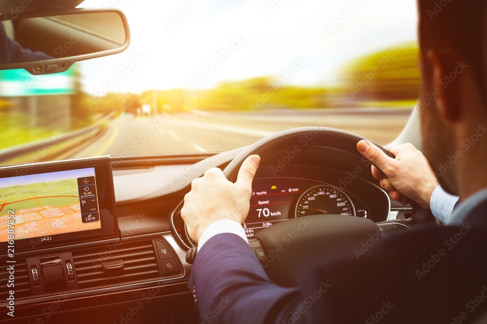 Poster back view of man driving with navigation system