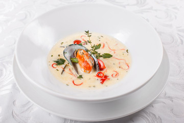 Cream soup with seafood, grilled prawns, mussels in a shell. Mediterranean restaurant menu