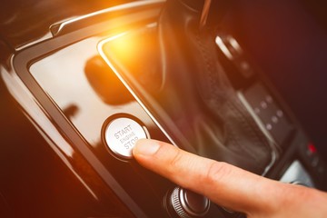 Man pressing start button in car