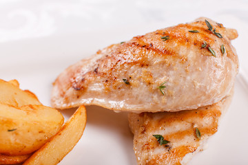 Hot and spicy hot meat dishes. Grilled chicken breast with french fries slices of rustic