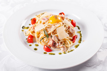 Spaghetti Carbonara. Italian Pasta on white plate with parmesan, ham and yolk