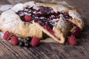 Galette with berries raspberries, strawberries and black currants with sugar powder