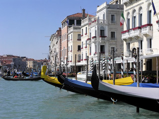 colorful gondolas at dock before elegant buildings in early morning and beginning of day