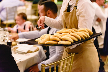 Waitress serving bread during a celebration.