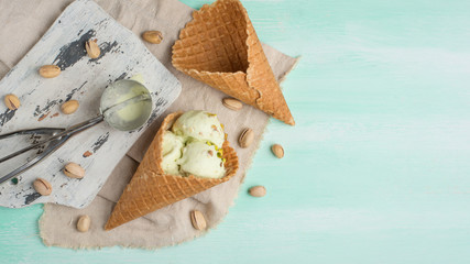 pistachio ice cream, sprinkled with nuts, in two classic bowls on a light wooden background