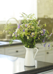 Bouquet of wildflowers in vase on kitchen table