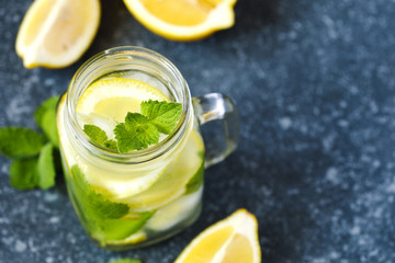 Mason jar glass of lemonade with mint on blue stone background