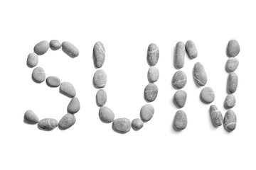 Pebbles on white background, sea pebble. Inscription, text, word: SUN