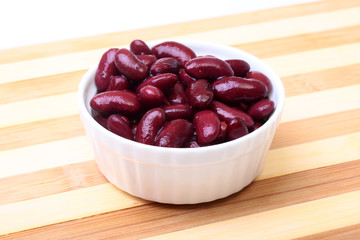 Heap of canned red kidney beans in the sauce in white bowl. vegetarian food. Phaseolus vulgaris.
