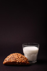 Seed bread and milk isolated on black background. Text place
