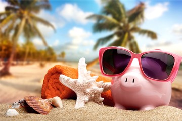 Piggy bank on sandy beach background