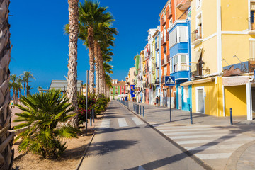 Colourful houses and palm trees on street in Villajoyosa, Spain.