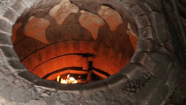 Traditional Bakery Tone or Torne or Turne for Baking a Georgian Shotis Puri or Shoti Bread. Cooking Process: Baker Shapes the Flat Bread and Sticking Dough to Wall of Oven and Taking Ready Shoti in