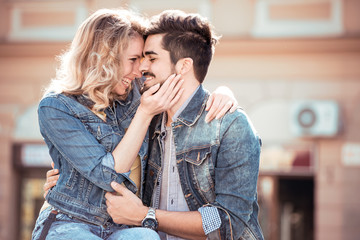 Cheerful smiling couple in love hugging on the street