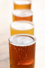 Close up on variety of craft beer in a line, with a bright white background