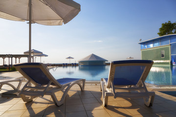Chaise lounges at pool in hotel