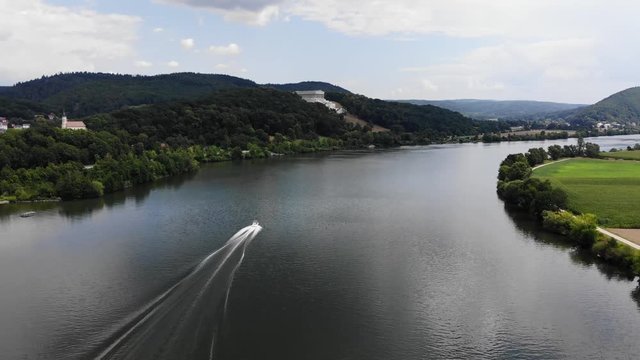 Aerial view of the Danube River and Walhalla memorial on the hill, Donaustauf, Bavaria, Germany. Speed boat sailing along the river