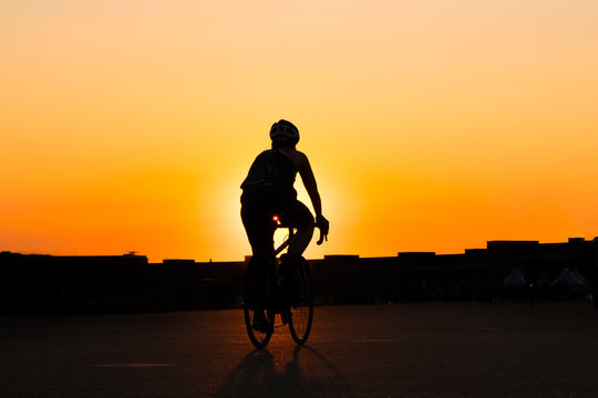 silhouette of a person riding bicycle with sunset sky  