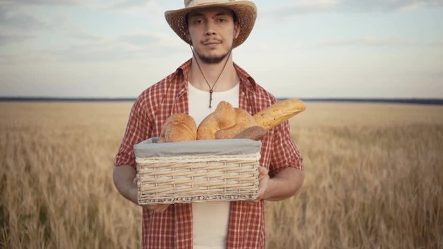 young farmer are stand along the wheat field with bread baskets