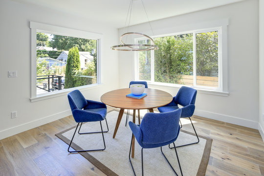 Modern dining room with wood table and blue chairs.