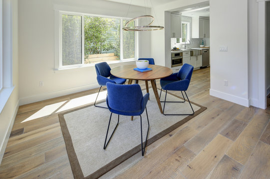 Modern dining room with wood table and blue chairs.
