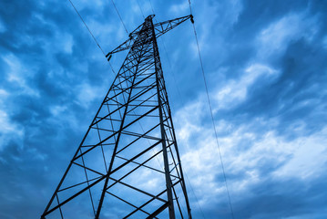 High voltage power pole close against evening sky
