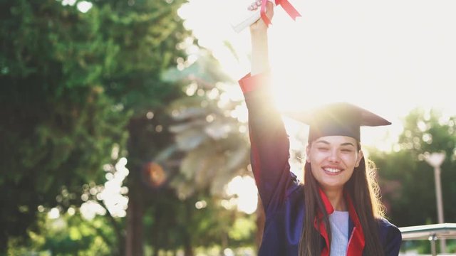 Graduated student raising her diploma up