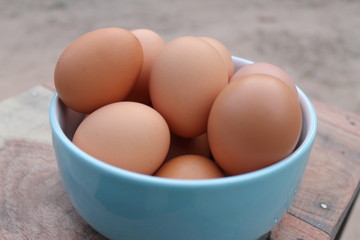 Close-up view of raw chicken eggs in blue bowl