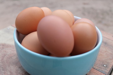 Close-up view of raw chicken eggs in blue bowl