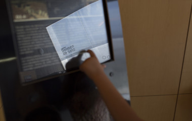 Fototapeta premium Młody gość korzystający z edukacyjnego interaktywnego ekranu dotykowego w centrum dla odwiedzających Dolmen de Soto, Huelva, Hiszpania