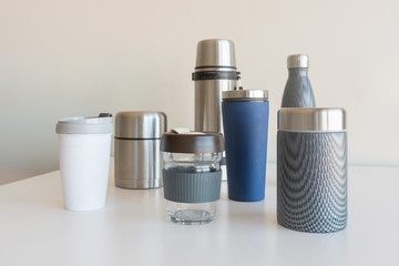 Collection of reusable food and drink containers on white table - sustainability concept (selective focus)