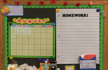 Grade school bulletin board with calendar and homework chart