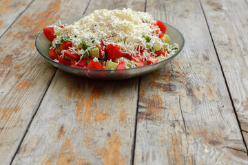 Fresh tomato and cucumber salad sprinkled with cheese