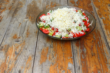 Fresh tomato and cucumber salad sprinkled with cheese