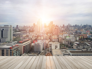 Wood balcony in with blurred abstract background of night light of cityscape growth.