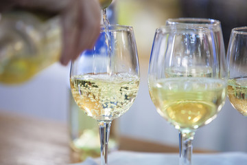 Glass with white wine poured on a cup