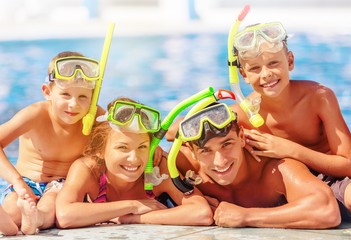 Obraz na płótnie Canvas Happy family playing in swimming pool