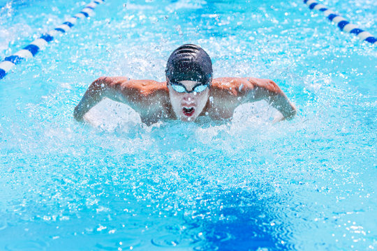 Teenage swimmer swimming butterfly stroke in a race