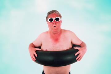 Sunburned man with sunglasses and inner tube