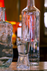 Glass of pinga with bottle, on bar table