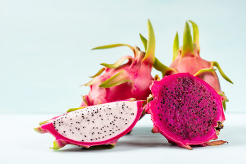 Half and slice dragon fruit on color background, tropical fruit